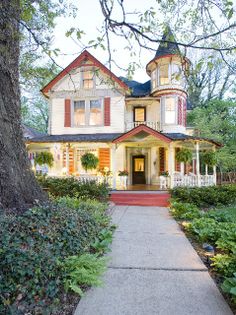 a large white house sitting next to a tree