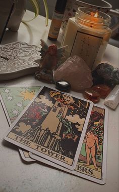 candles, rocks, and cards on a table with some items in the background to spell out tarot