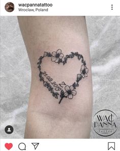 a heart shaped tattoo with flowers on the side of the leg and an inscription that says love