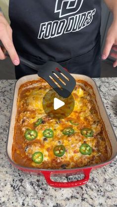 a person is using a spatula to stir food in a casserole dish