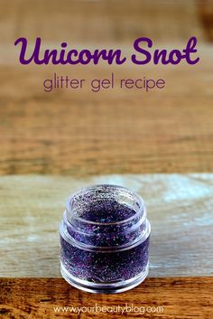 a jar of glitter on top of a wooden table with the words unicorn snott written