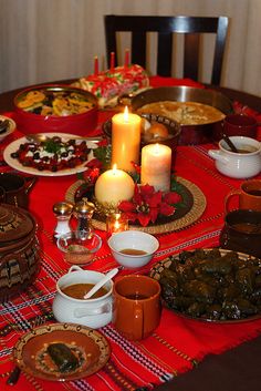 a table is set with food and candles for the holiday dinner guests to eat at