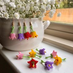 the beaded flowers are sitting on the window sill next to the flower pot