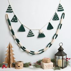 a christmas garland is hanging on the wall next to candles and other holiday decor items