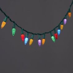 multi - colored christmas lights are hanging on a string