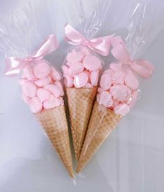 three ice cream cones with pink marshmallows wrapped in cellophane wrap