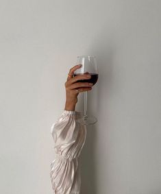 a woman holding a wine glass up to her face