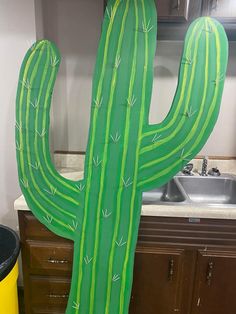 a large green cactus sitting next to a sink