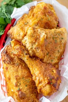 some fried food is in a basket on a table with parsley and cilantro