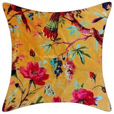 a yellow pillow with colorful flowers and birds on it