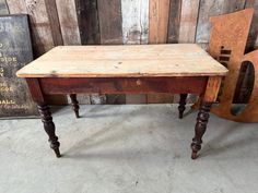 an old wooden table with two chairs next to it