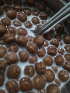 meatballs are being cooked in a pan with milk