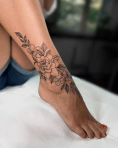 a woman's foot with a flower tattoo on her left side and the bottom part of her leg