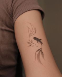 a woman's arm with a fish tattoo on it