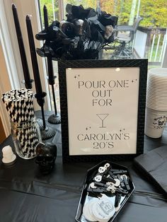 a table topped with black and white decorations next to a sign that says pour one out for