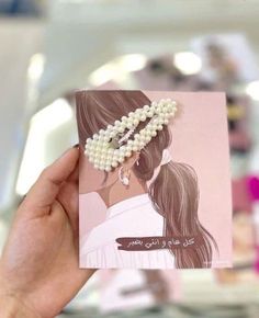 a person holding up a card with pearls on it