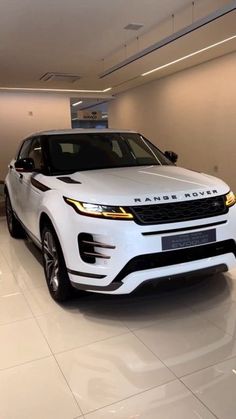 a white range rover parked in a showroom with no one around it on the floor