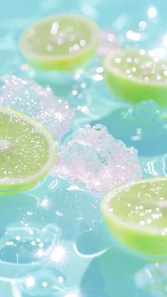 limes floating in water with bubbles on the bottom and one slice cut out to look like it is melting