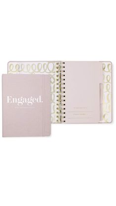 an open notebook sitting on top of a white book with the word engaged printed on it