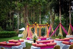 an outdoor wedding setup with pink and yellow decorations