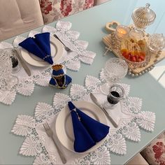 the table is set with blue napkins and white placemats, silverware