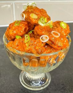 a glass bowl filled with food on top of a counter