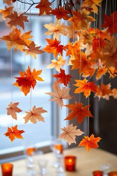 an arrangement of autumn leaves hanging from a chandelier