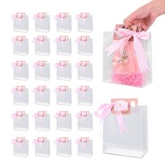 a hand is holding a bag with pink bows on it and twelve bags in the background