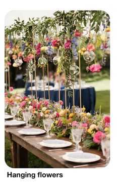 a long table with plates and flowers on it is set up for an outdoor event