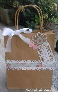 a brown paper bag with white ribbon and lace