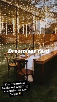 a long wooden table sitting under a canopy covered in fairy lights with the words dreamfest yard on it