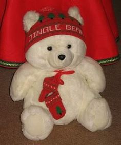 a white teddy bear wearing a red hat and scarf