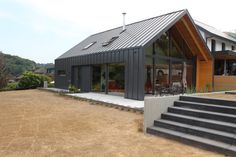 a house with a metal roof sitting on top of a dirt field