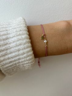 This silk cord bracelet is a fresh take on a friendship bracelet. It is made with high quality materials. You can choose the cord colour, the gemstone and charm of your choice. D E T A I L S  *It features a small  AA quality gemstone/pearl in between seamless gold filled beads and a tiny 18k gold filled charm. Charm measures between 5.5 mm and 6mm and is free moving *The cord is natural silk cord that has been twisted for strength and doubled over. Cord measures 0.6mm. *Choose the cord colour you prefer from the drop down menu. *If the silk should arrive kinked it will straighten itself out after a few hours after coming into contact with your skin. *You can expect the ends to flare creating a pretty tassel. *Bracelet is adjustable just move the slider bead up and down. *It comes with a cr Pink Nylon Cord Bracelets As Gift, Pink Nylon Cord Bracelet As A Gift, Pink Nylon Cord Friendship Bracelets As A Gift, Nylon Cord Bracelet, Silk Cord Bracelet, Bracelet Pearl, Bracelet Friendship, Beads Bracelet Design, Tassel Bracelet