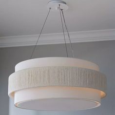 a light fixture hanging from the ceiling in a room with gray walls and white trim