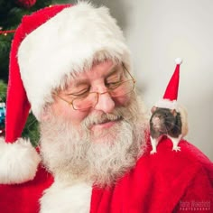 a black and white photo of santa claus holding a rodent