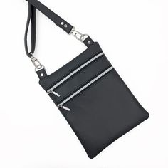 a black purse with two zippers hanging from it's side, on a white background