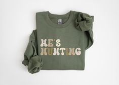 He's Hunting Sweatshirt! Cute Retro style font in multiple colors give this sweatshirt a cute trendy design! Perfect gift for an abandoned hunting wife or hunters girlfriend!  How to Place an Order 1. Select your preferred size, color, and any custom options. 2. Click "Add to Cart" to save the item. 3. Click "Proceed to Checkout." 4. Enter your shipping address. 5. Choose and enter your payment details. 6. Submit the order!  **Production and Shipping ✨ **Processing Time   Custom orders are created by the designer/shop owner, who strives to process each order as soon as it comes in, or at the latest, within 24 hours. Our production timeline generally follows at 2-7 business days depending on order size, product availability, and time of year. In short, once you place an order from our shop, Sims 4 Hunting Cc, Hunting Season, Sweatshirt Cute, Deer Hunting, Shop Owner, Baby Bag, Cut And Style, Retro Style, Add To Cart