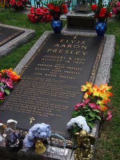 a grave with flowers on it in the grass