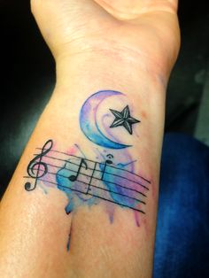 a person's wrist with musical notes and a star on it