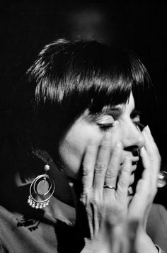 a black and white photo of a woman holding her face to her mouth with both hands