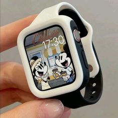 someone is holding up a watch with mickey mouse on it's face and the time