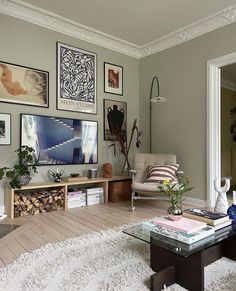 a living room filled with lots of furniture and pictures on the wall above it's coffee table