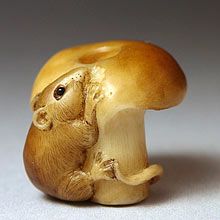 a small figurine of a mouse on top of a mushroom