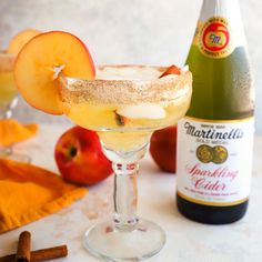 an apple cider cocktail garnished with cinnamon sprinkles and apples