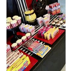 a table topped with lots of different types of snacks and desserts on top of red trays