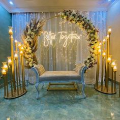 a white couch sitting under a lit up sign next to a blue bench with flowers on it