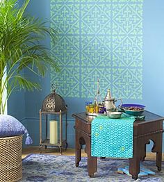 a living room with blue walls and rugs on the floor next to a table