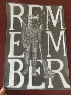 a person holding up a piece of paper with the words rem ber on it