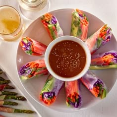 a white plate topped with asparagus and dipping sauce